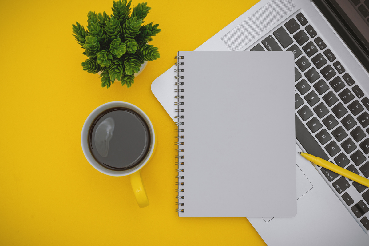 Notepad and Laptop on Yellow Background